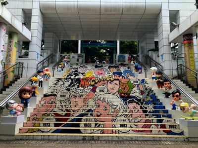 A public staircase painted with comic characters, figures standing on the steps