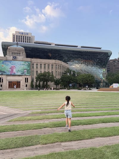 Seoul Plaza, the old city hall and the new one behind her