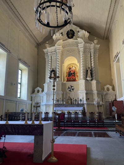 The white baroque altar inside St Dominic's, a chandelier overhead