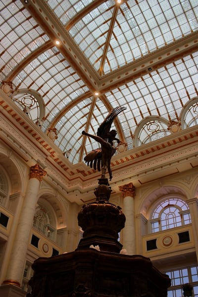 A winged bronze figure beneath a glass dome