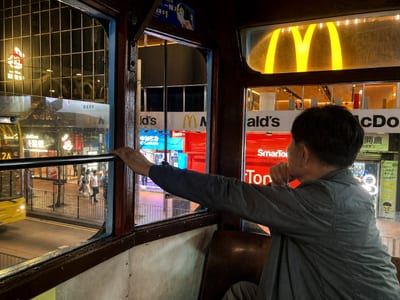 My father looking out of the tram window at the lit street