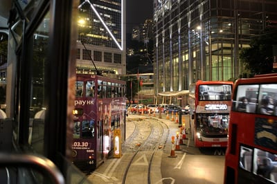 Tram tracks curving into the night city, seen from the upper deck